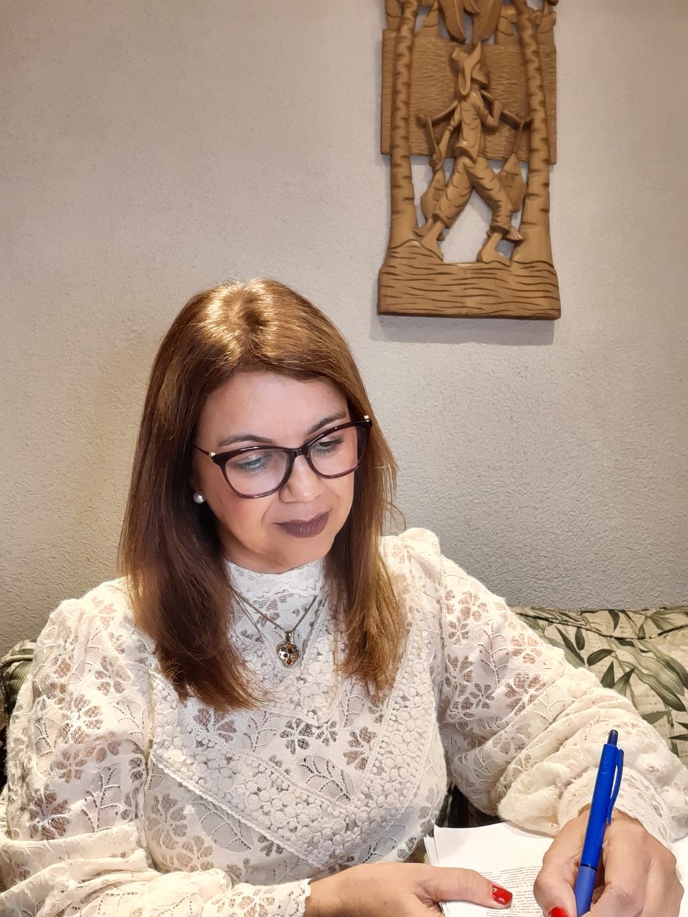 Katia Reis fazendo anotações em sua mesa de trabalho
